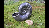 Spiral ammonite shell sculpture welded from pipe elbows and forged rod |  Set down outdoors on moss, the finished piece works as more than a sculpture....